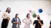 Group of observers stand in museum among various networks.